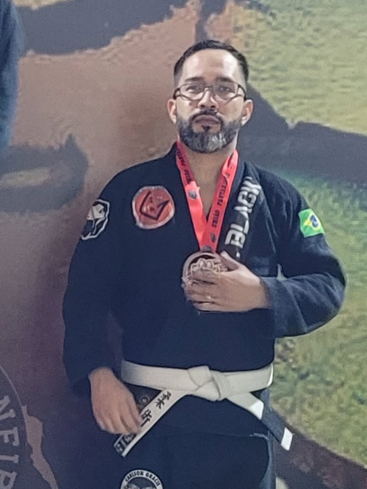 Atleta de kimono preto exibindo medalha no campeonato