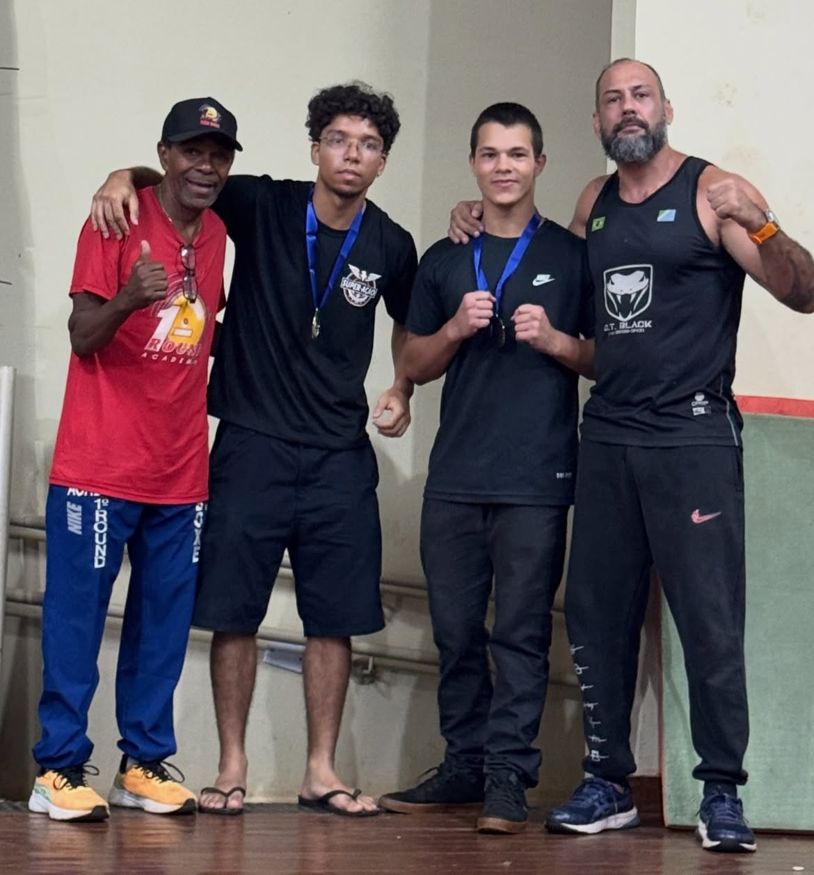 Treinador e atleta com medalhas após a competição de ringue