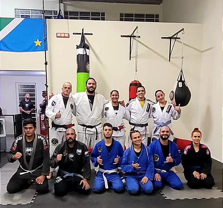 Turma de Jiu-Jitsu com kimonos brancos, azuis e pretos no tatame do CT Black Viper